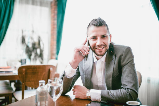 istock Smiling Business Man With Braids Make Phone Call in Restaurant 955240456
