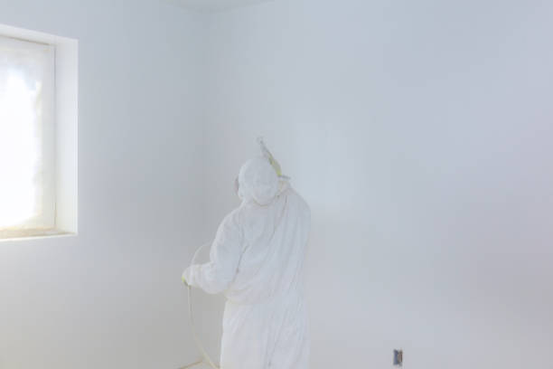 istock Worker painting wall with spray gun in white color. 955250970