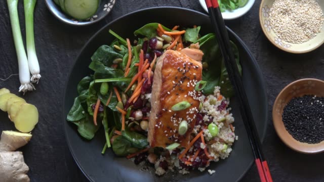 Grilled Salmon on a Spinach Salad with Quinoa, Carrots, Cranberries, Chickpeas, Edemame, Pumpkin Seeds, and a Ginger Miso Dressing.