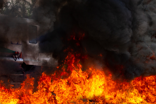 Blaze fire is burning with black smoke. Backside is the head of fuel tanker truck.