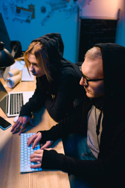 istock confident couple of hackers working on malware together in dark room 955252694