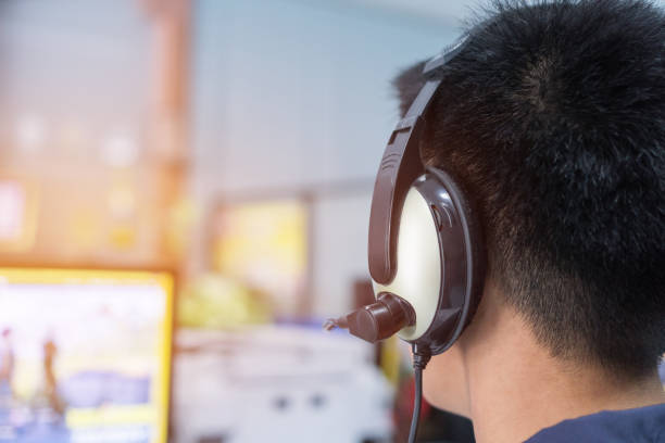 istock Education e-learning foreign languages Concept : Asian Student Young man wearing Headphones listening English songs music and searching for learning abroad in computer pc at classroon of university 955253116