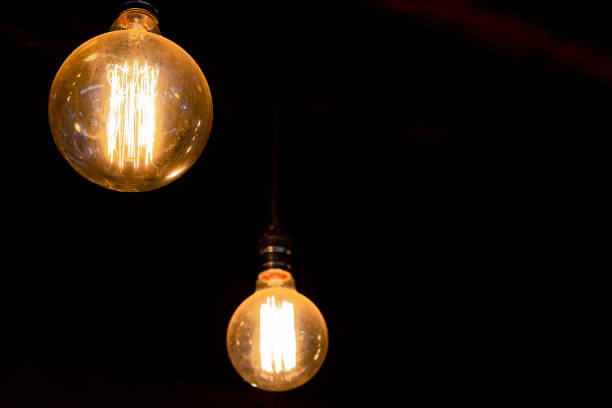 istock Vintage round tungsten filament bulb with dark background 955256634