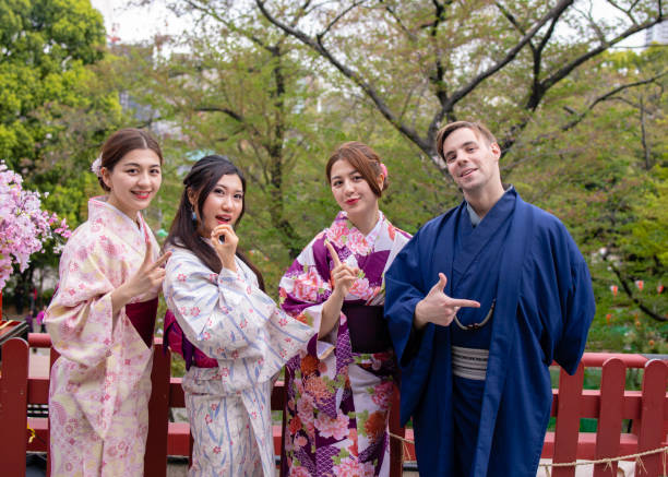 Multi-ethnic couple in kimono making 2018 by their hands
