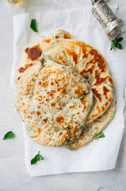 istock Indian flatbread - Herb stuffed paratha on a baking paper 955263864