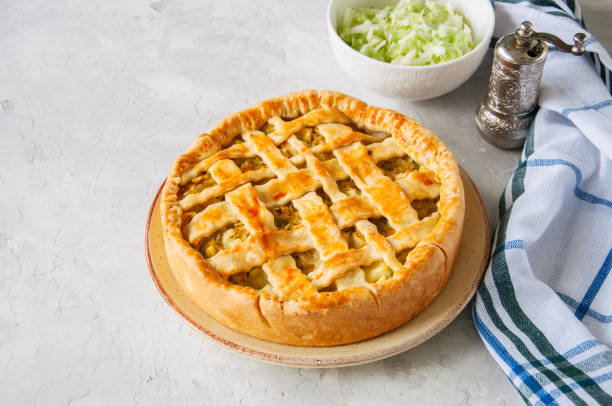 istock Homemade young cabbage pie from flaky dough  served on a plate. White stone background. 955263878