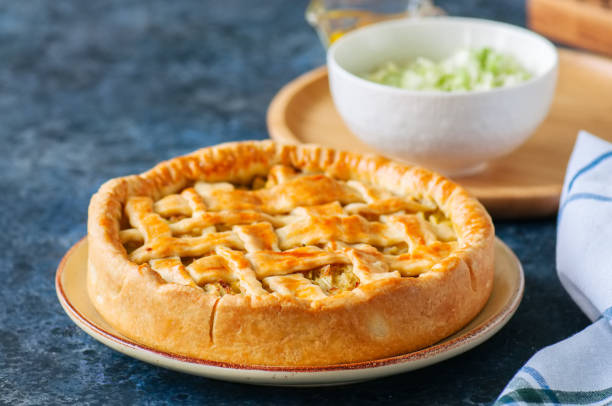 istock Homemade young cabbage pie from flaky dough  served on a plate. blue stone background. 955263880