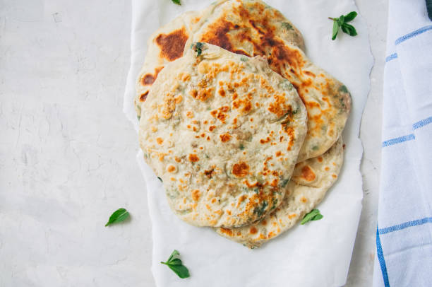 istock Indian flatbread - Herb stuffed paratha on a baking paper 955263882