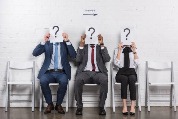 istock obscured view of multicultural business people holding cards with question marks while waiting for job interview 955268036