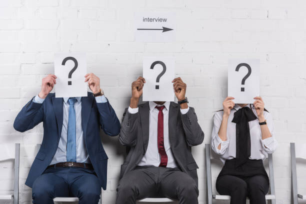 istock obscured view of multicultural business people holding cards with question marks while waiting for job interview 955268144