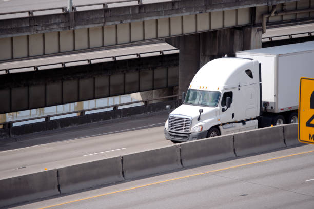 istock Big rig semi truck with semi trailer driving on multi-level overpass road 955268616