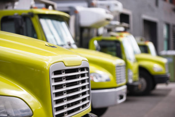 istock Middle class semi trucks with box trailers for moving and delivery services standing in row in warehouse dock waiting for customers 955268946