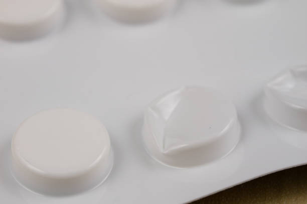 istock Pills in a wrapper on a wooden table. A medicine for a cold and a headache in a plastic package. Light background. 955272446