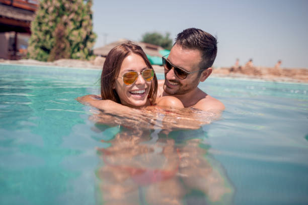 istock Loving happy couple in pool 955272774