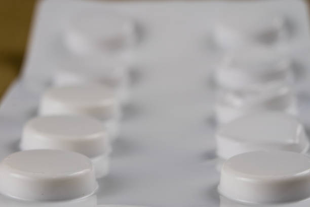 A white pill bottle with a white pill inside. High quality photo