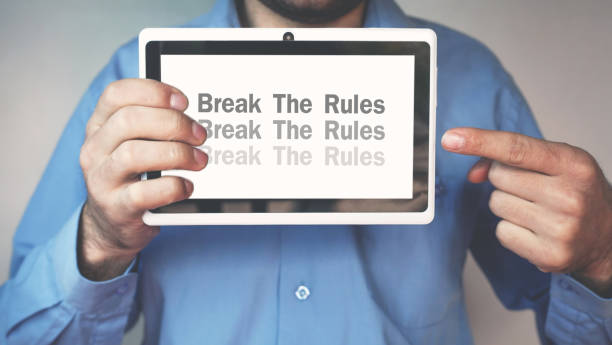 istock Businessman pointing Break The Rules word on a tablet screen. 955277562