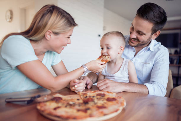 istock Family eating pizza at home 955277606
