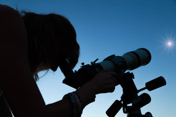 istock Woman looking at the stars with a telescope. 955294706