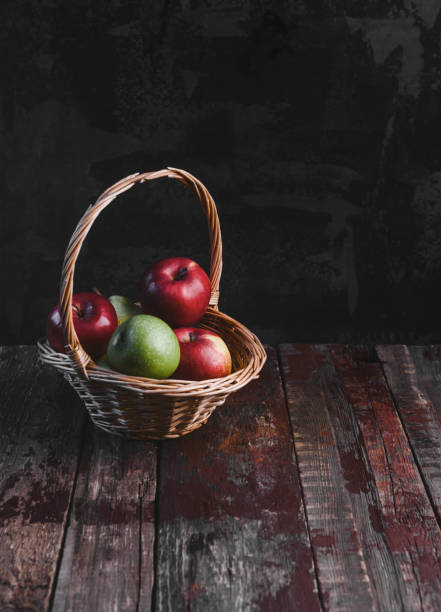 istock pile of apples in wicker basket on rustic wooden table 955298756