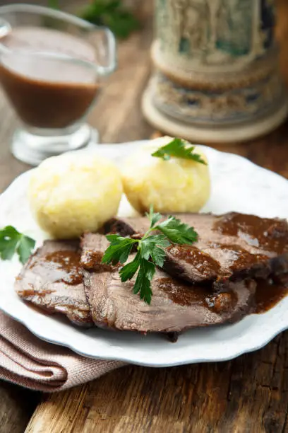 Baked meat or Sauerbraten with spicy sauce and potato dumplings