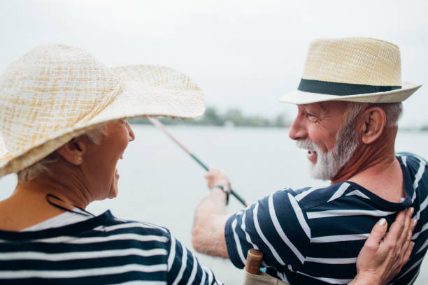 Grandfather and his nephew fishing together near river outdoors
