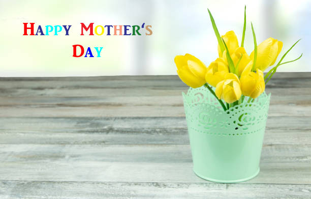 Mothers day greeting card. Mothers day greeting card. Decorative composition of yellow tulips on rustic bright wooden table.The bunch of yellow tulips is in decorative green vase. Empty space for your design. Card concept for mothers day. collorful stock pictures, royalty-free photos & images