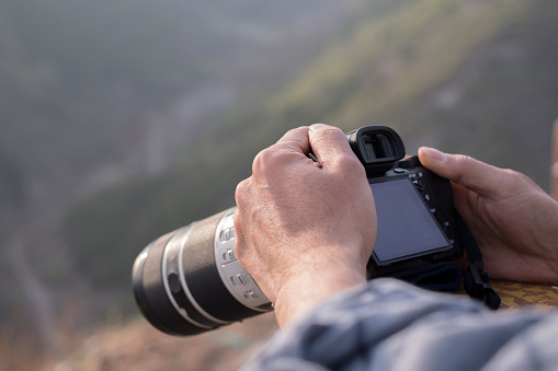 hand holding camera on top of mountain