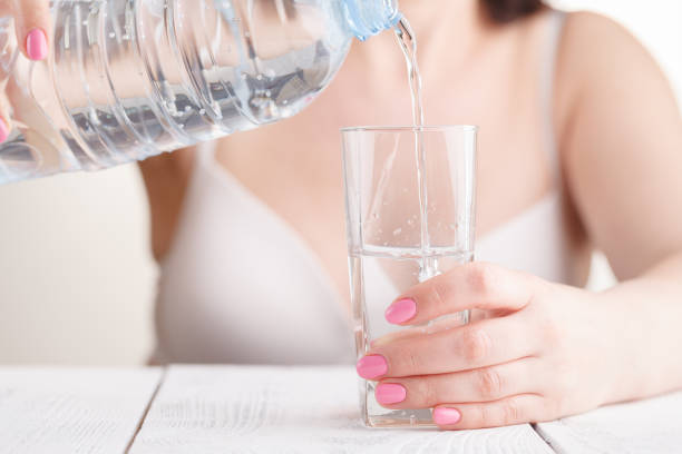 istock Pouring water from bottle into glass 955323916