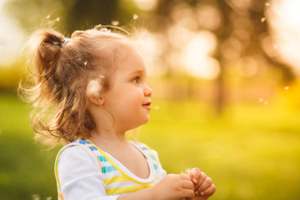 istock Girl among dandelion flying seeds 955333452
