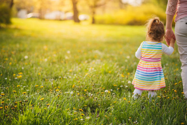 istock Mother and daughter walking in the park 955336384