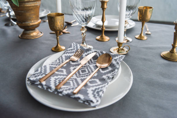 istock close up view of rustic table setting with old fashioned cutlery and napkin on plates, candles and empty wine glasses on surface 955336950