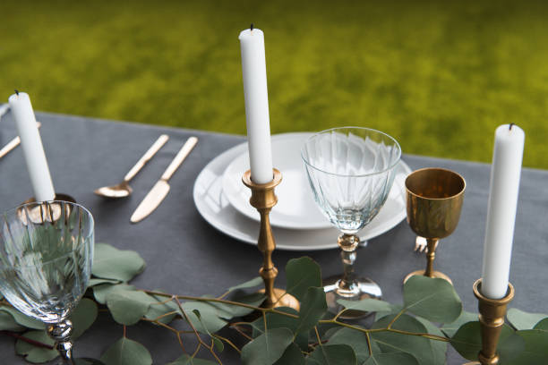 istock close up view of rustic table setting with wine glasses, eucalyptus, old fashioned cutlery, candles in candle holders and empty plates 955337754
