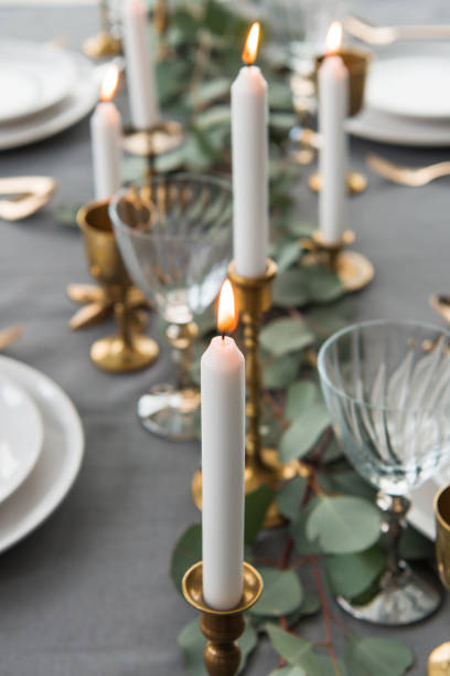 istock selective focus of rustic table setting with eucalyptus, old fashioned cutlery, candles in candle holders and empty plates 955337864
