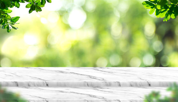 istock Empty white marble table top with blur tree in park with bokeh light at background,Mock up template for display of your design,Banner for advertise of product,panorama view 955338768
