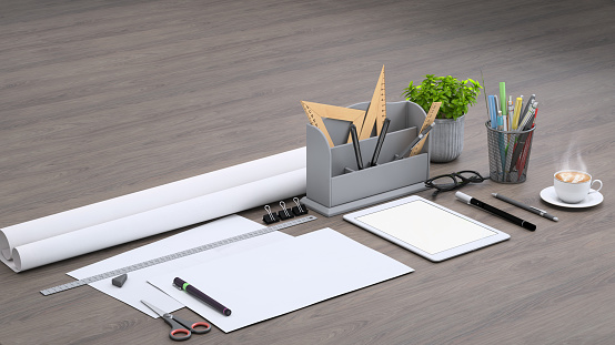 Diagonal composition, architect designer desk with papers, rulers, pencils and office accessories, warm coffee and blank digital tablet. Plant in a vase.  Mock up background template