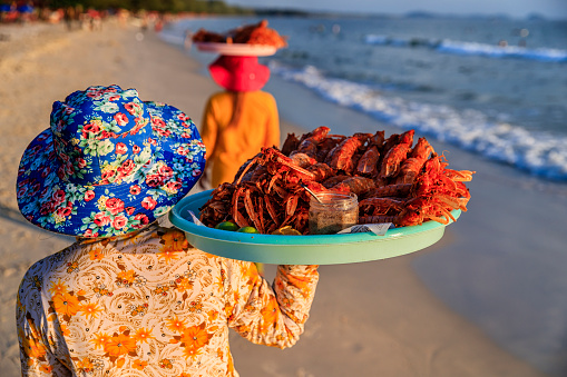 Happy Cambodian women selling fresh lobsters on the beach, Sihanoukville, Cambodia