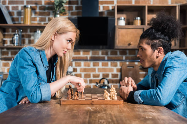 istock side view of multiethnic young couple playing chess together in kitchen 955366240