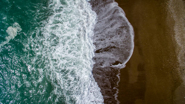 istock Aerial view waves break on white sand beach. 955375006