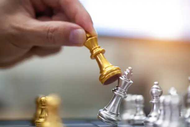 Photo of hand of businessman playing chess.