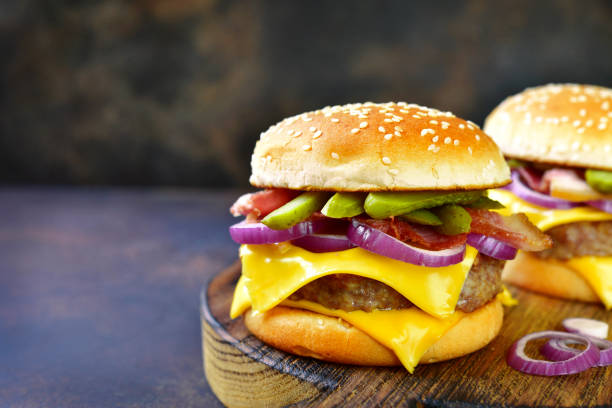 istock Cheeseburger with beef cutlet, fried bacon and pickled cucumber 955393200