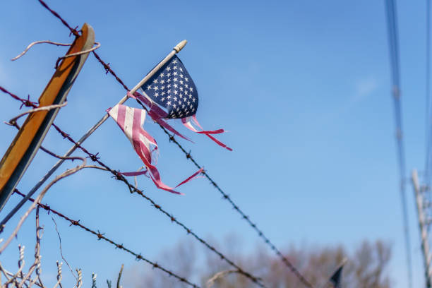 istock American Flag on Barbed Wire Fence 955397730