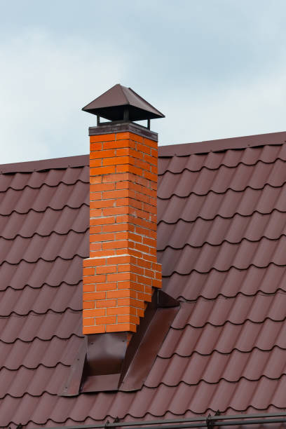 istock Red brick chimney pipe at home a background of blue sky 955411288