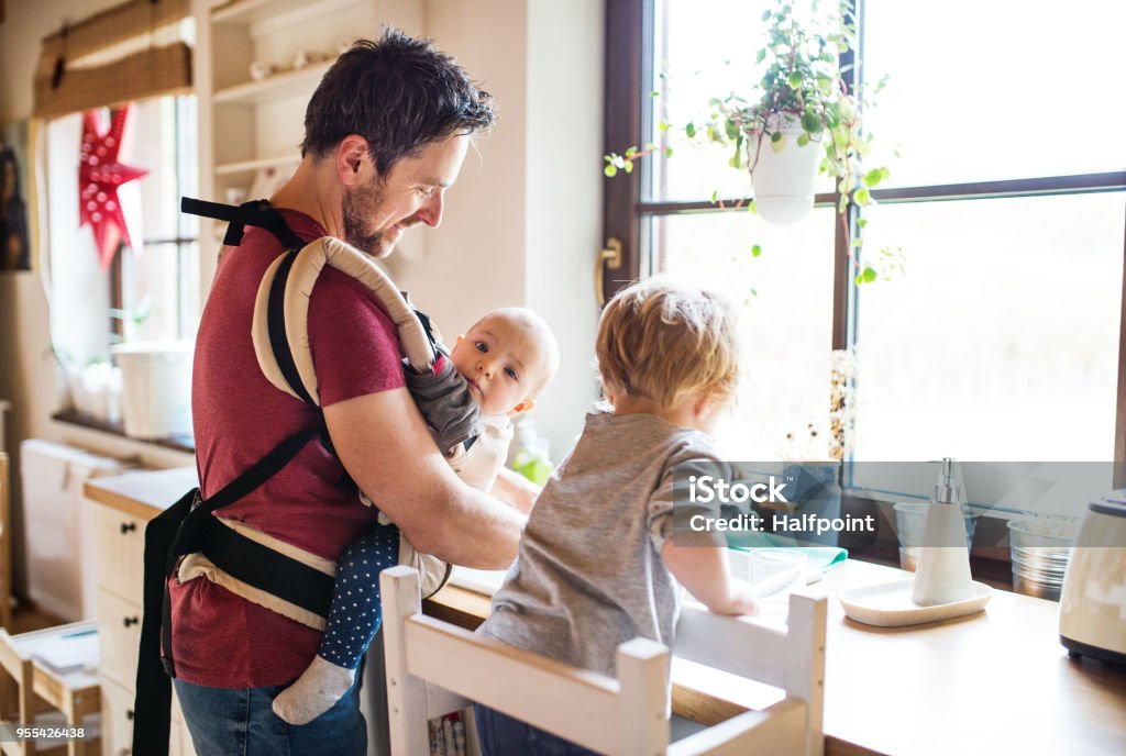 Father and two toddlers washing up the dishes. Handsome father and two toddlers washing up the dishes. Father Stock Photo