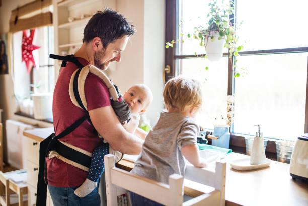 Father and two toddlers washing up the dishes. Handsome father and two toddlers washing up the dishes. father housework stock pictures, royalty-free photos & images