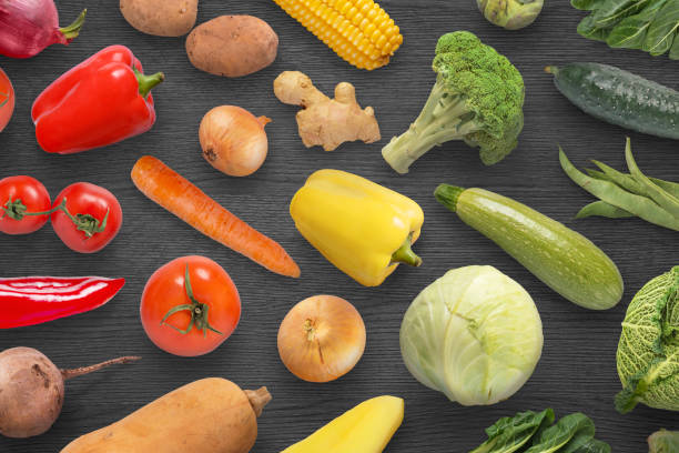 istock Colorful, red, orange, yellow and green vegetables on black surface. 955448046
