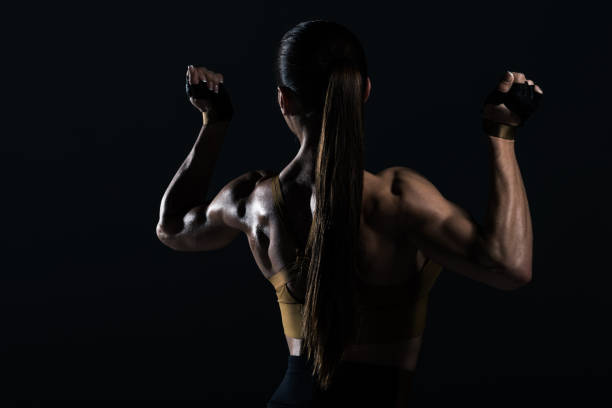 istock back view of strong female bodybuilder posing and showing muscles, isolated on black 955452894