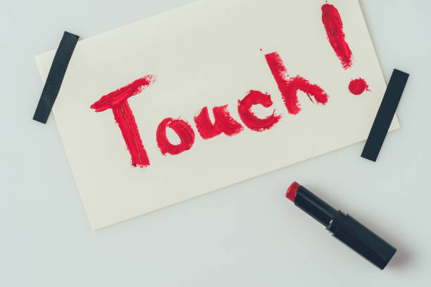 istock top view of note with word touch and lipstick isolated on white 955463692