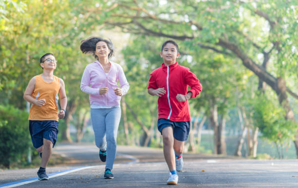istock Asian family practicing yoga outdoor at public park 955466752
