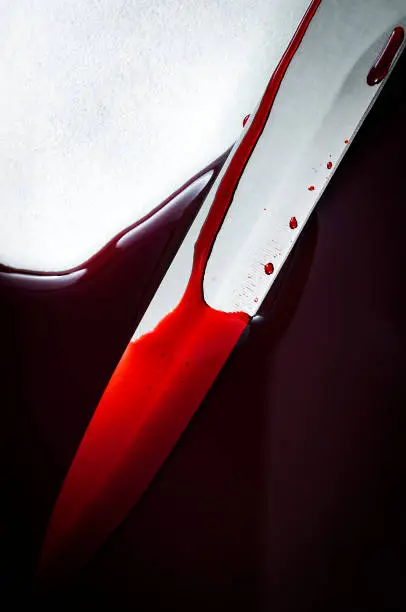 Photo of sharp big knife at murder scene in pool of blood