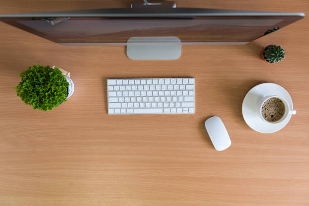 istock All in one computer, mouse, keyboard, cactus and plant vase  on wooden table. Flat lay style 955487990